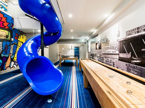 A resident game room with slide, shuffleboard, and table tennis